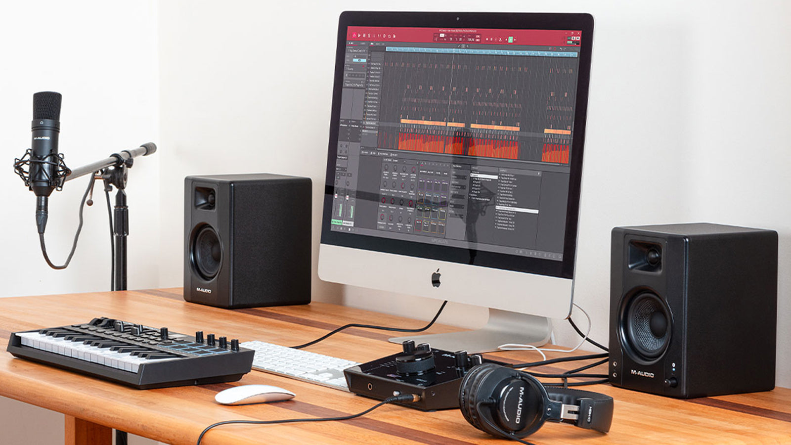 A pair of M-Audio monitor speakers on a desk in a home studio