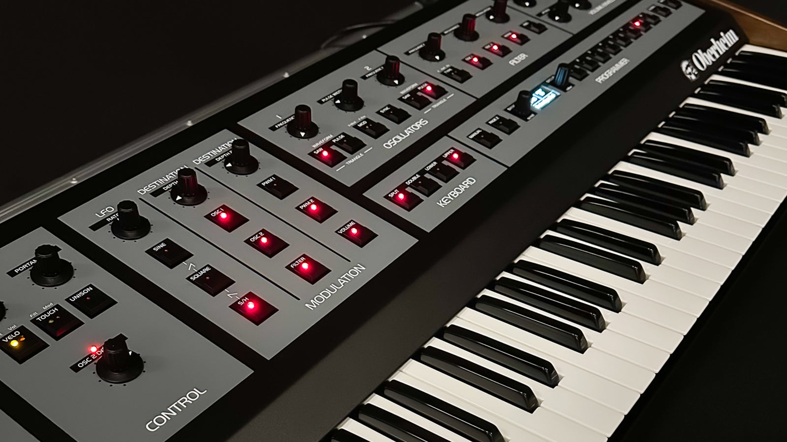 An Oberheim synthesizer on a desk in a home studio