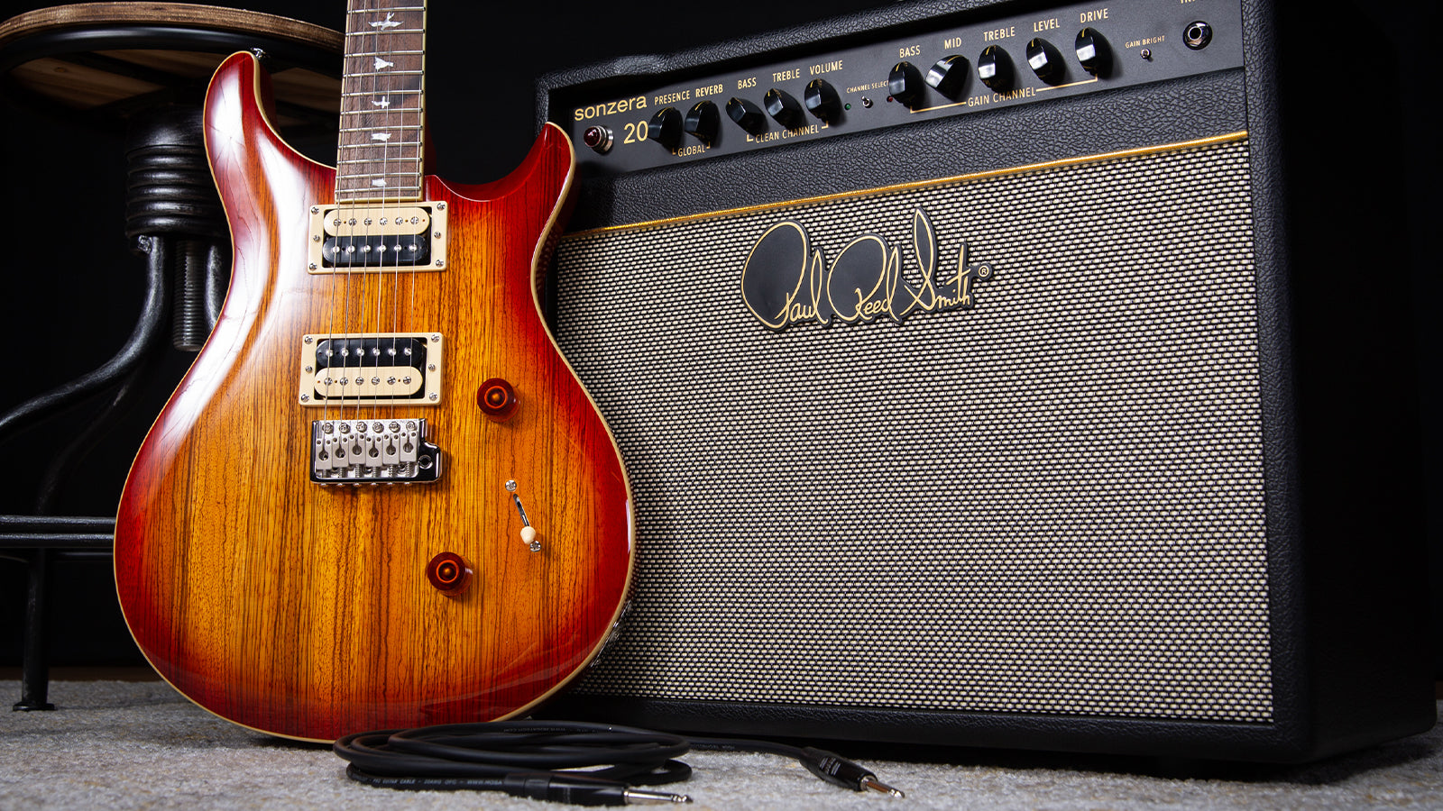 A PRS guitar leaning against a PRS amplifier