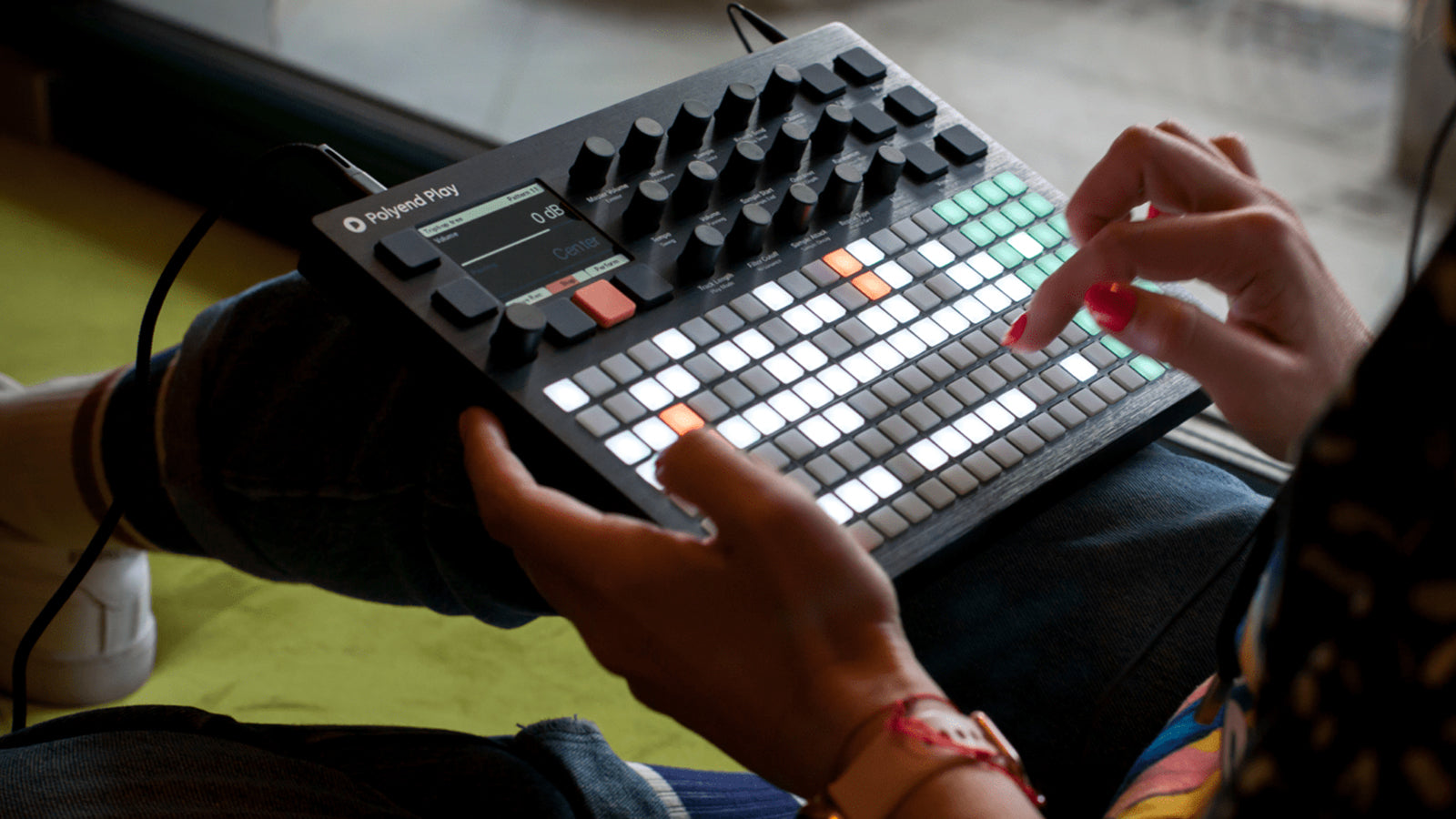 A young lady operating a Polyend synthesizer