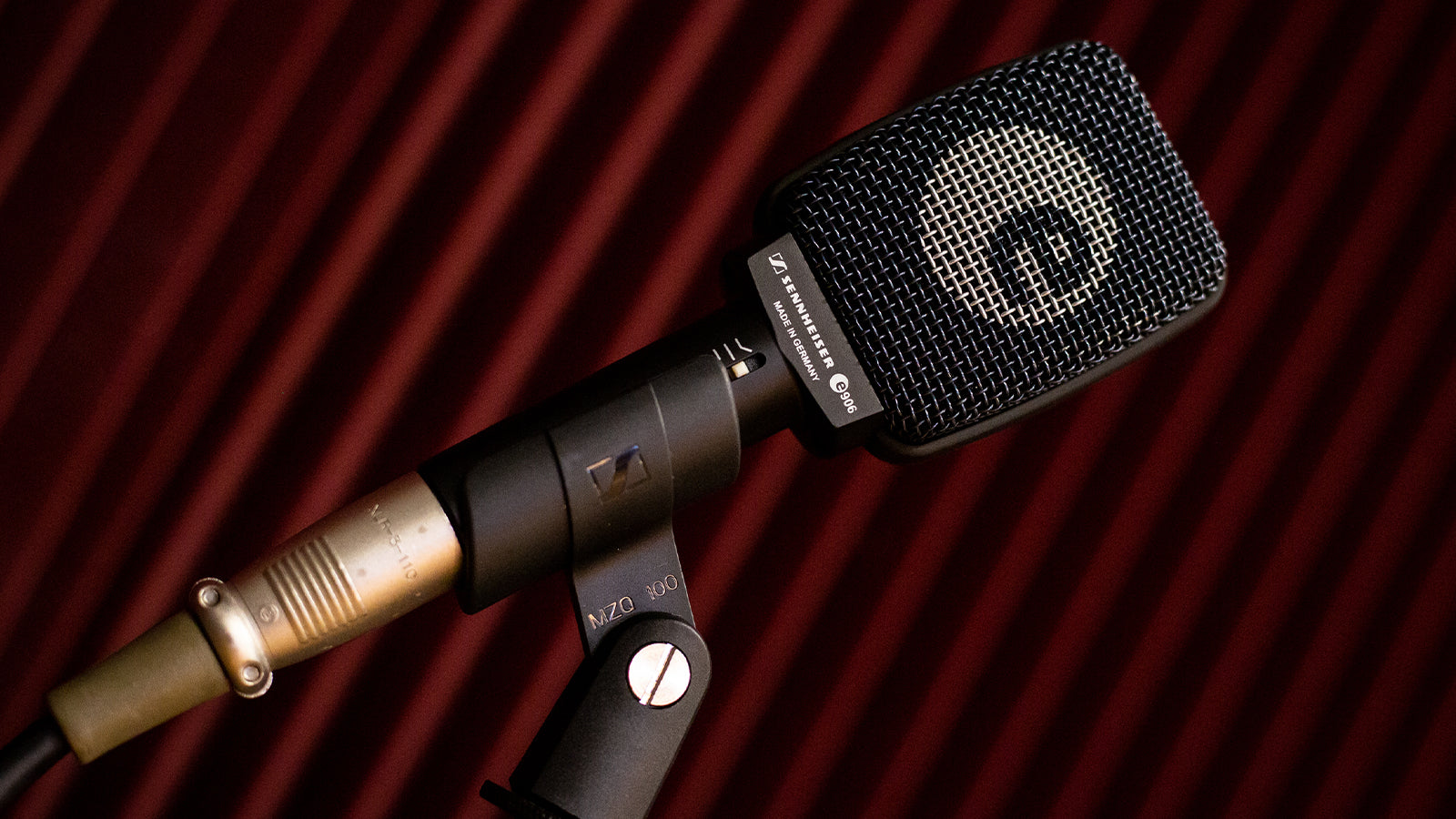 A Sennheiser microphone in a studio with acoustic foam in the background
