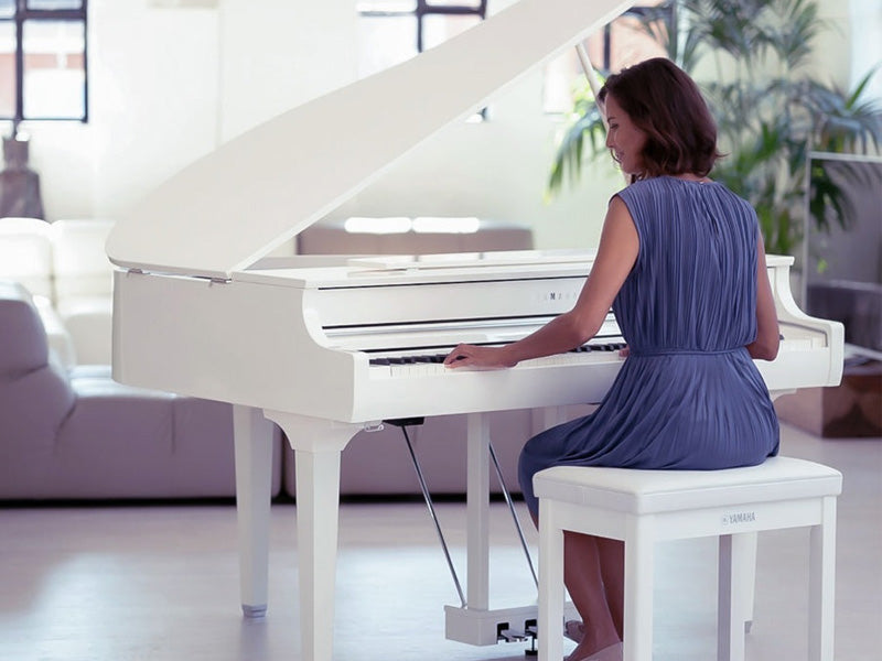 Woman at white Yamaha digital grand piano