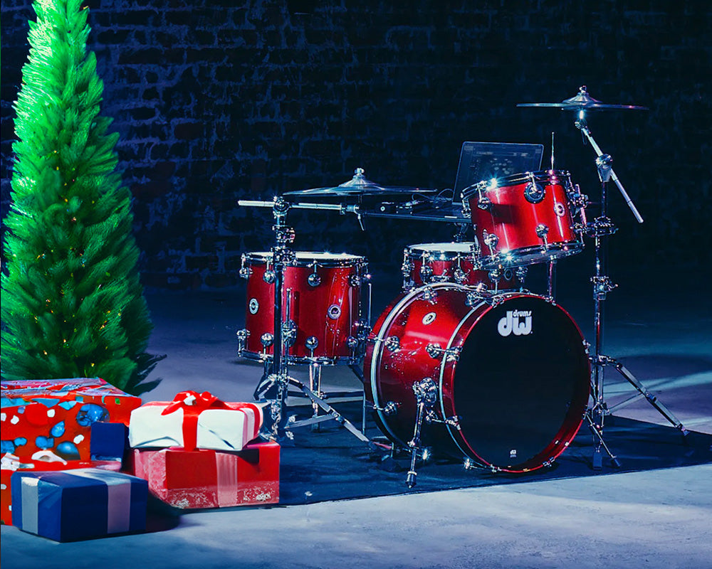 DWe drum set next to a Christmas tree and presents