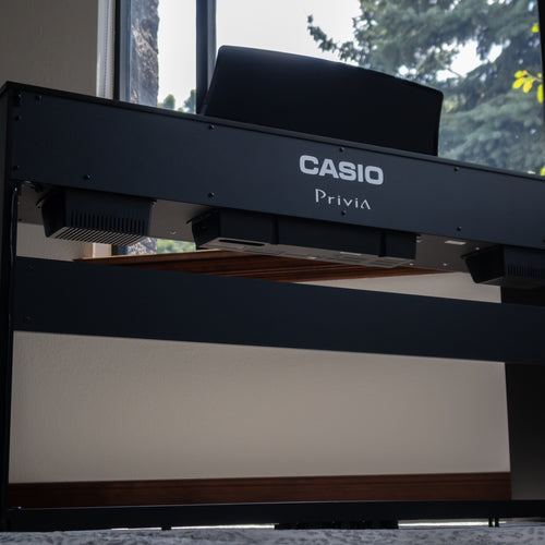 Casio Privia PX-765 Digital Piano - Black in a room with a window in the background