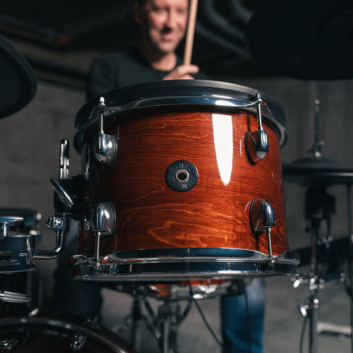 Drummer playing a Gretsch Catalina EVO Walnut Glaze electronic drum kit, rack tom in foreground