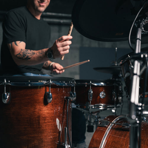 Drummer playing Gretsch Catalina EVO Walnut Glaze kit, floor tom in foreground
