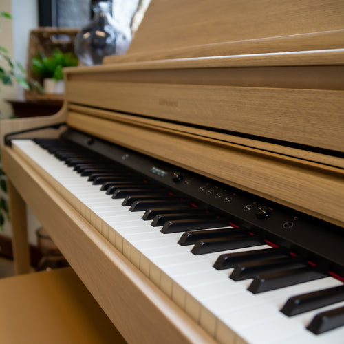 Close-up of a Roland HP704 Digital Piano with a Light Oak finish