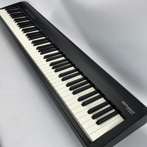 A Roland digital piano shown at an angle, featuring a black body, black and white keys, and the Roland logo on the side.