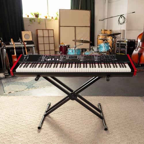 Roland V-Stage 88 Stage Keyboard on a stand in a music studio with musical instruments in the background