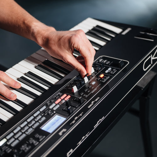 Close-up of a musician adjusting the organ drawbars on the Yamaha CK76 stage keyboard