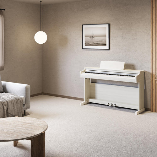 Modern living room with a white digital piano, gray sofa, and wooden coffee table.