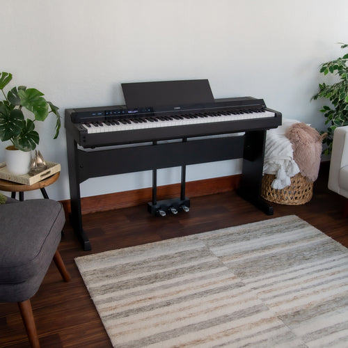 Yamaha P-S500B Digital Piano with L-300B Stand and LP-1B Triple Pedal - Black - in a room with a rug, plants, and furniture.