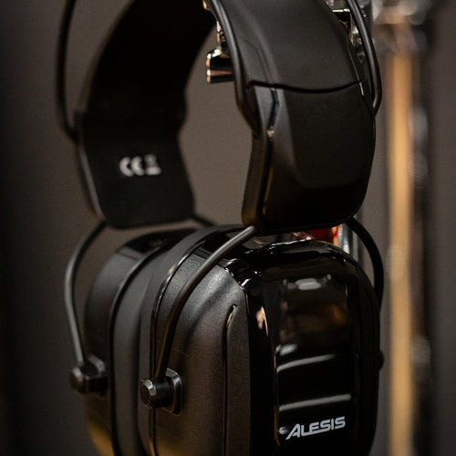 View of the Alesis DRP100 Electronic Drum Reference Headphones hanging on a drum hardware stand