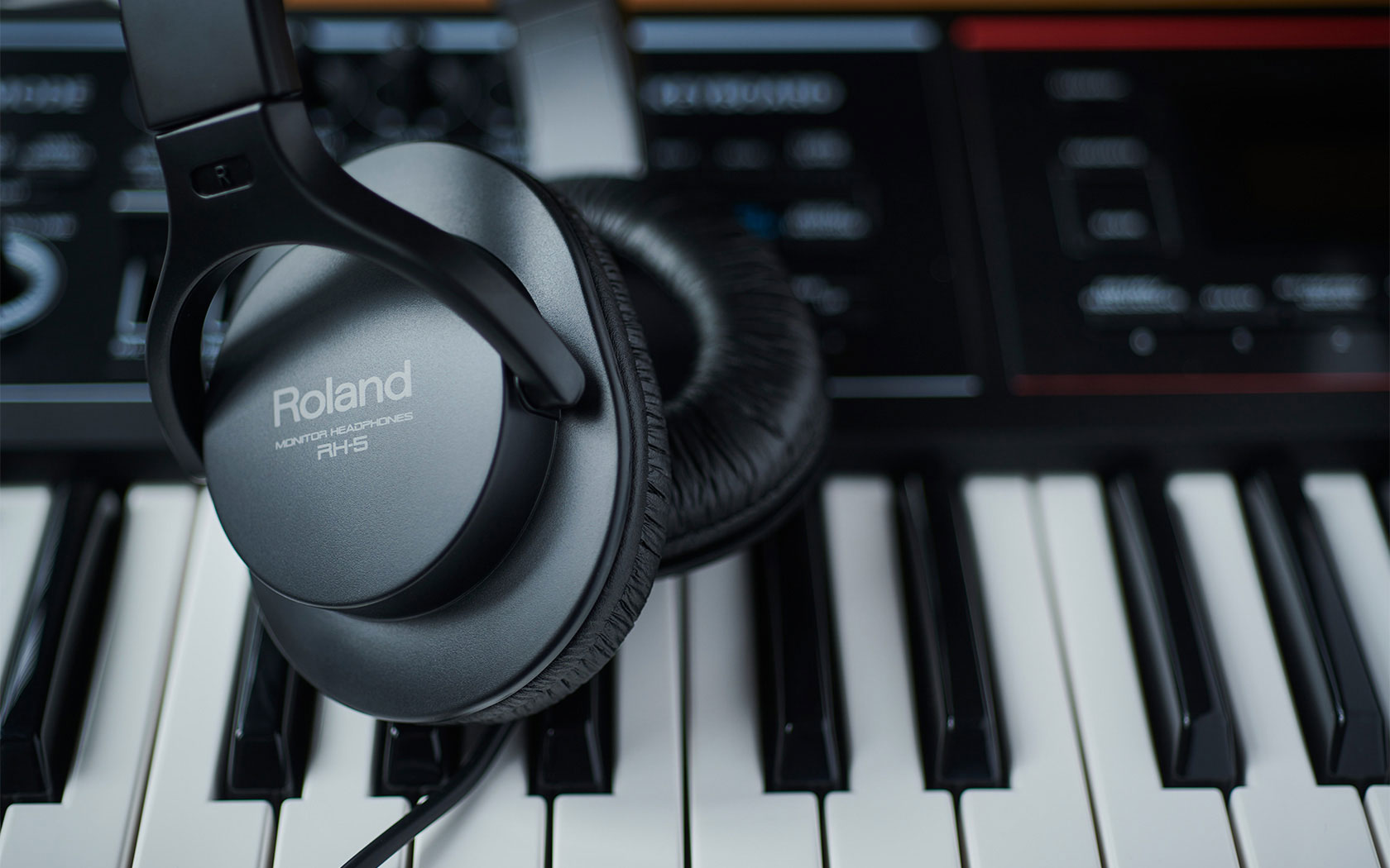 Lifestyle image of the Roland RH-5 Stereo Headphones - Black, laying over a keybed