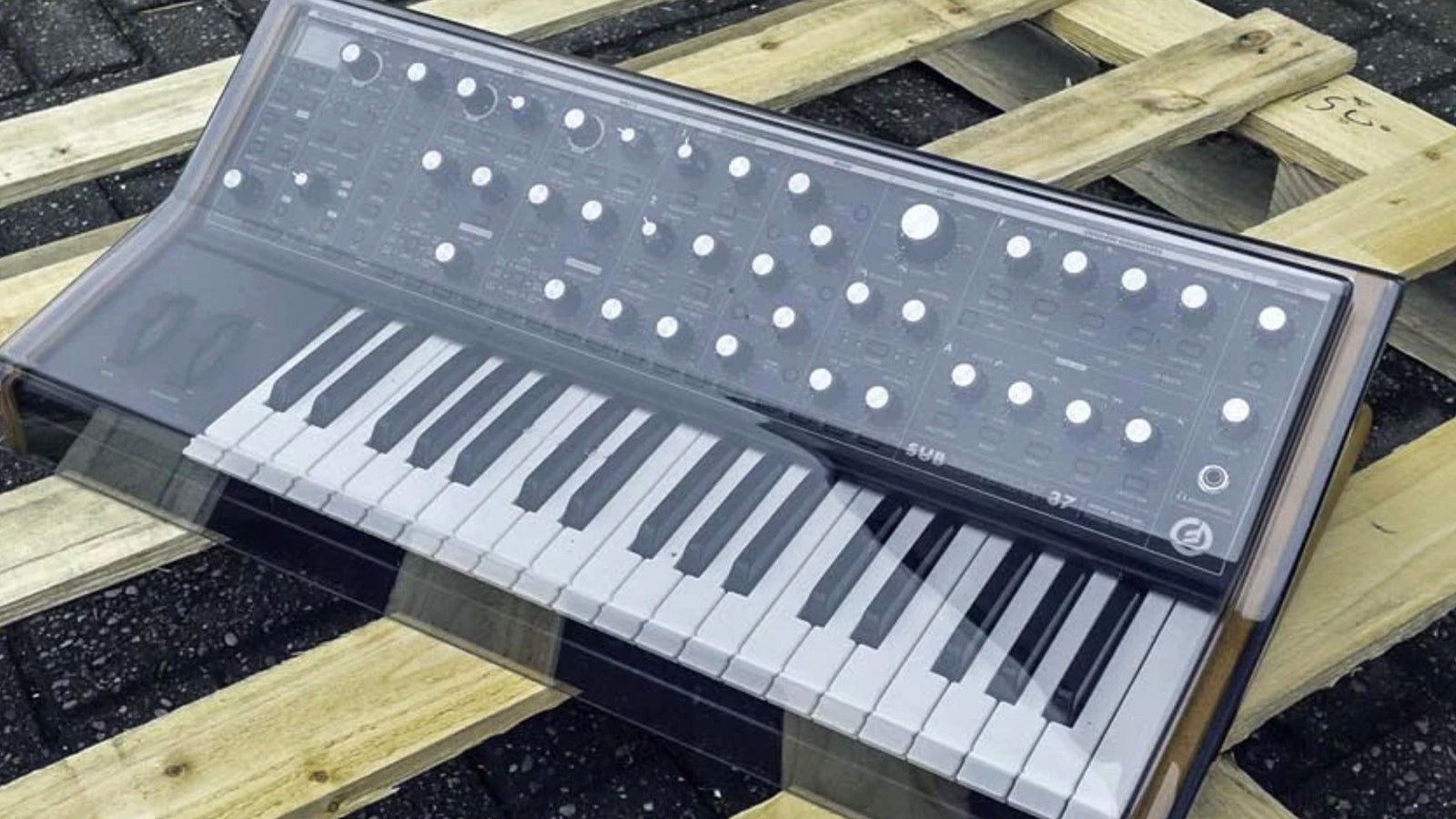A Decksaver on a Moog Subsequent 37 resting on a wooden pallet