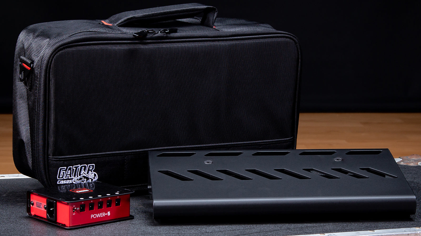 A Gator case, pedalboard, and power supply on a road case