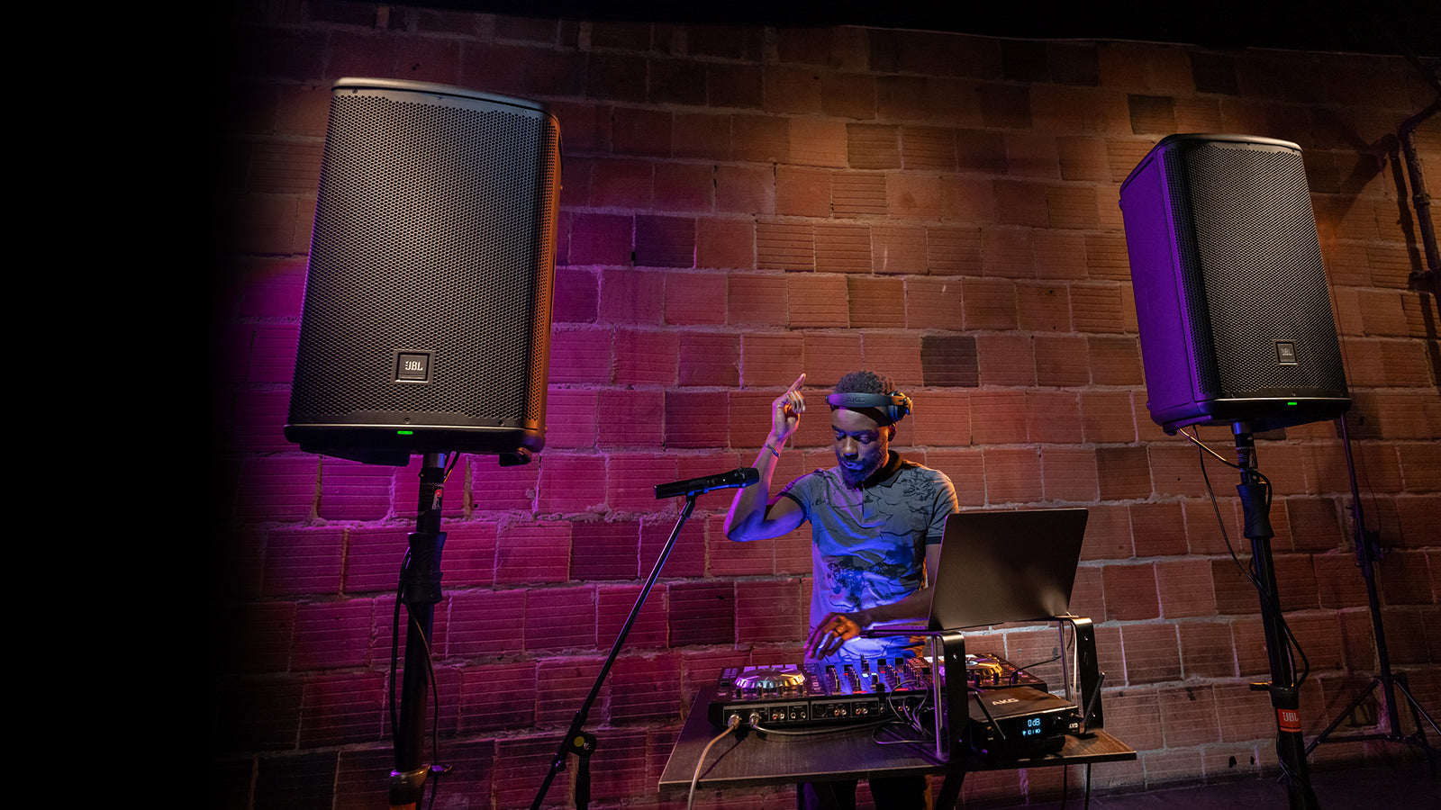 A DJ performing wiht JBL PA speakers