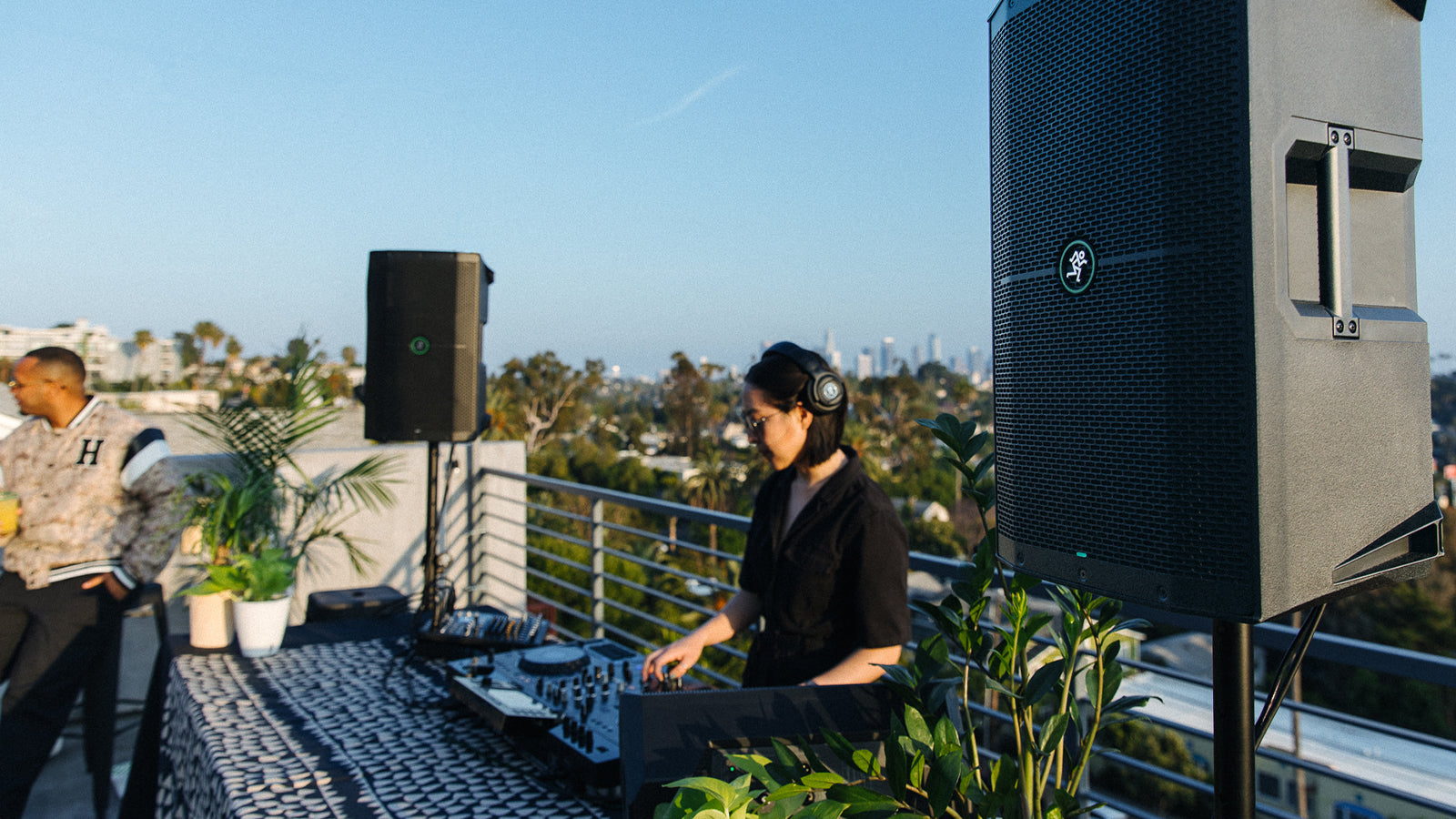 A dj using the Mackie Thump speakers in an outdoor setting