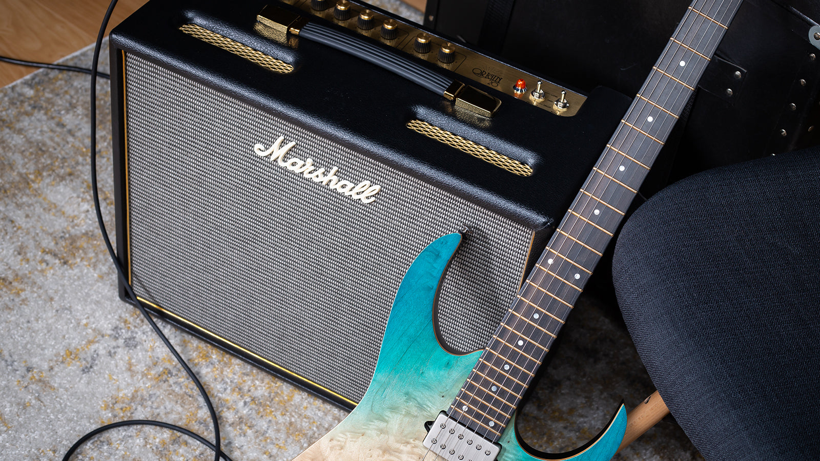 A Marshall amp with an electric guitar leaning on it
