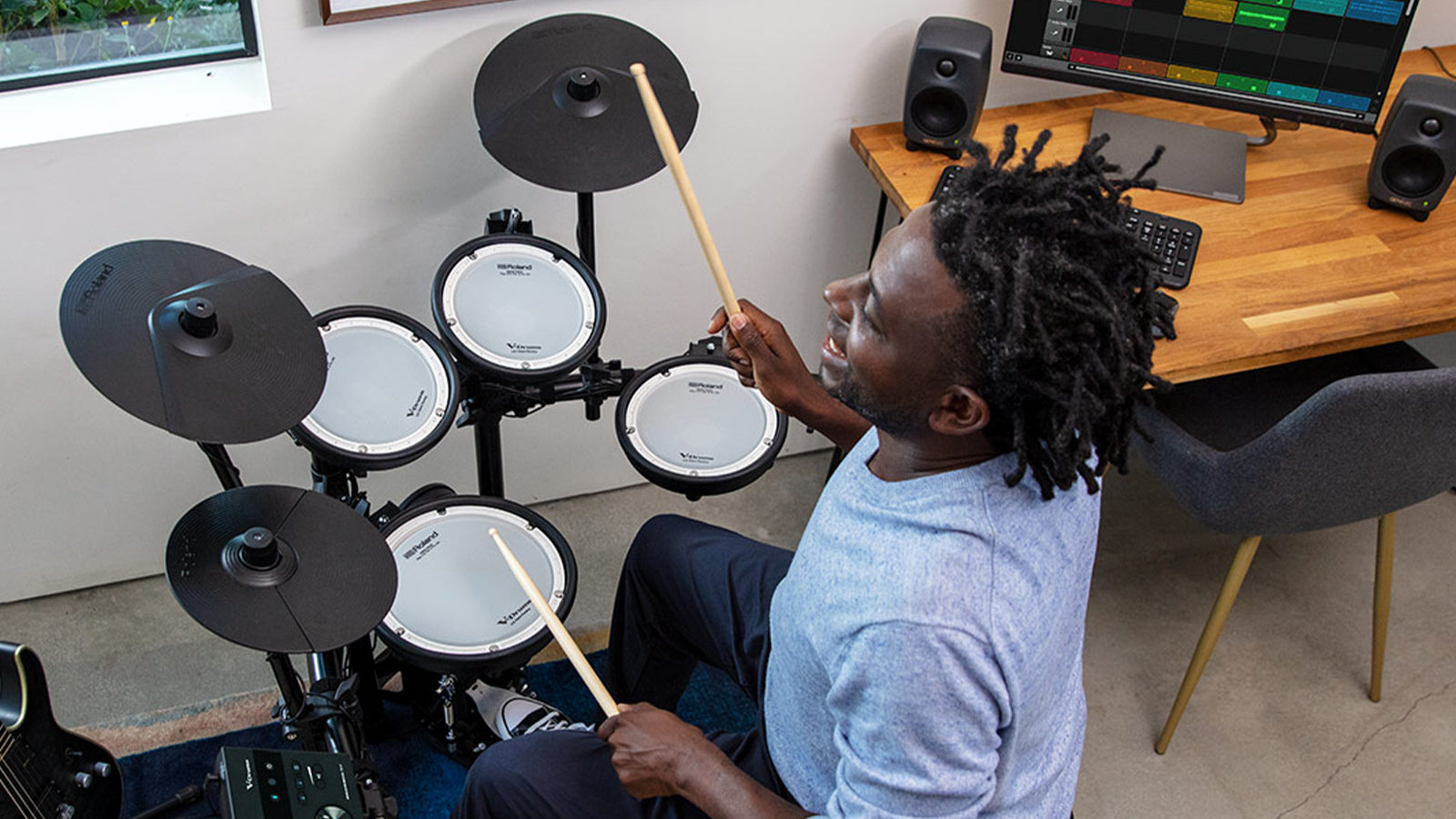 A young man playing a Roland TD-07KV drum set