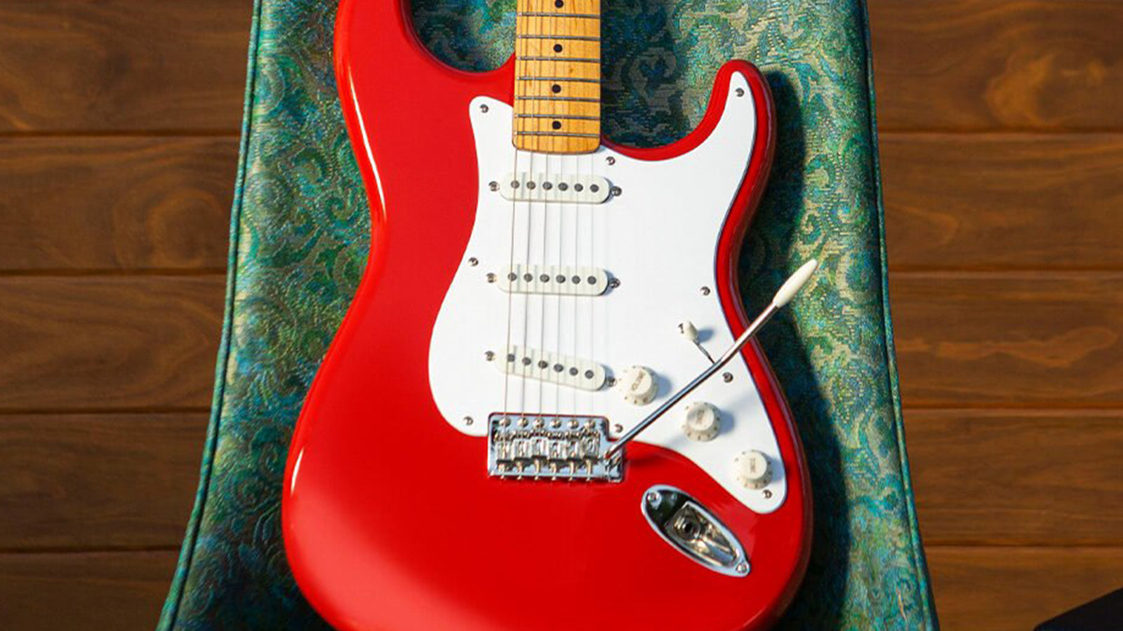 A Squier by Fender Stratocaster resting on a retro looking chair