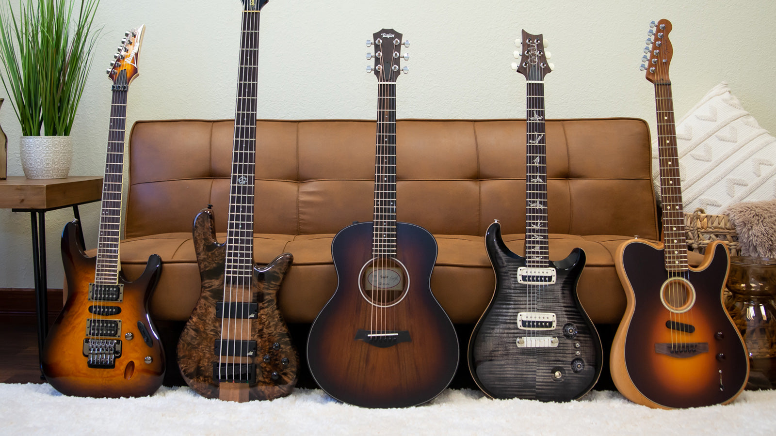Image of guitars and basses leaning against a couch