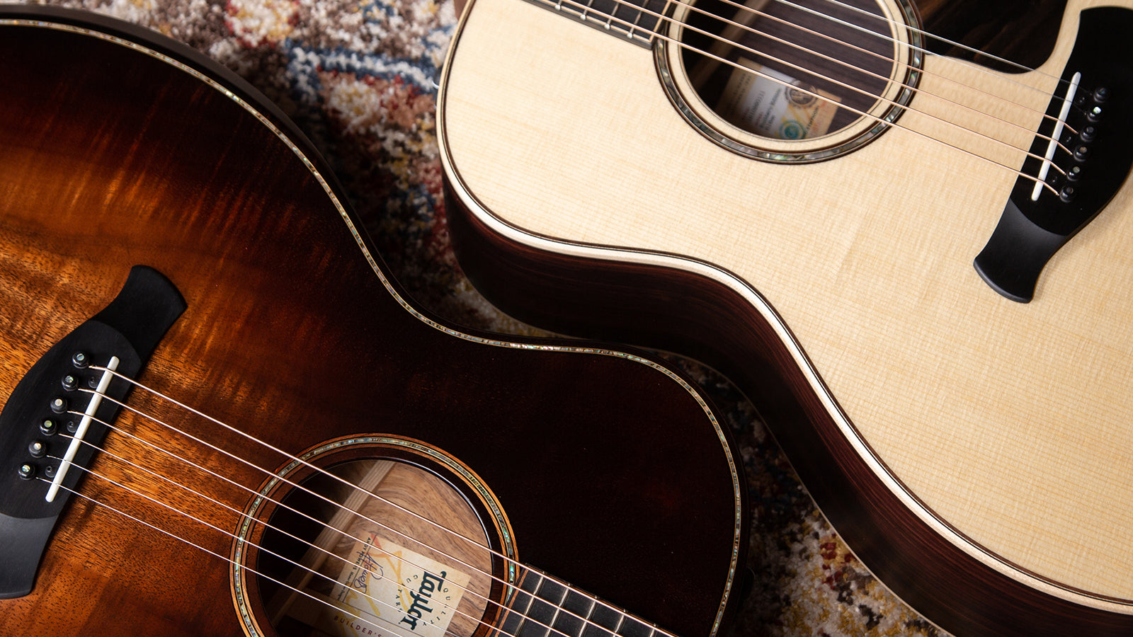 Two Taylor guitars laying on a stylish rug