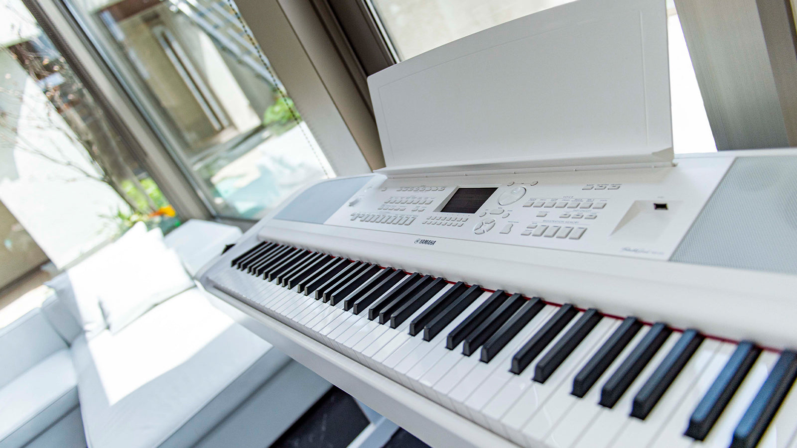 A white Yamaha DGX-670 in a modern stylish living space