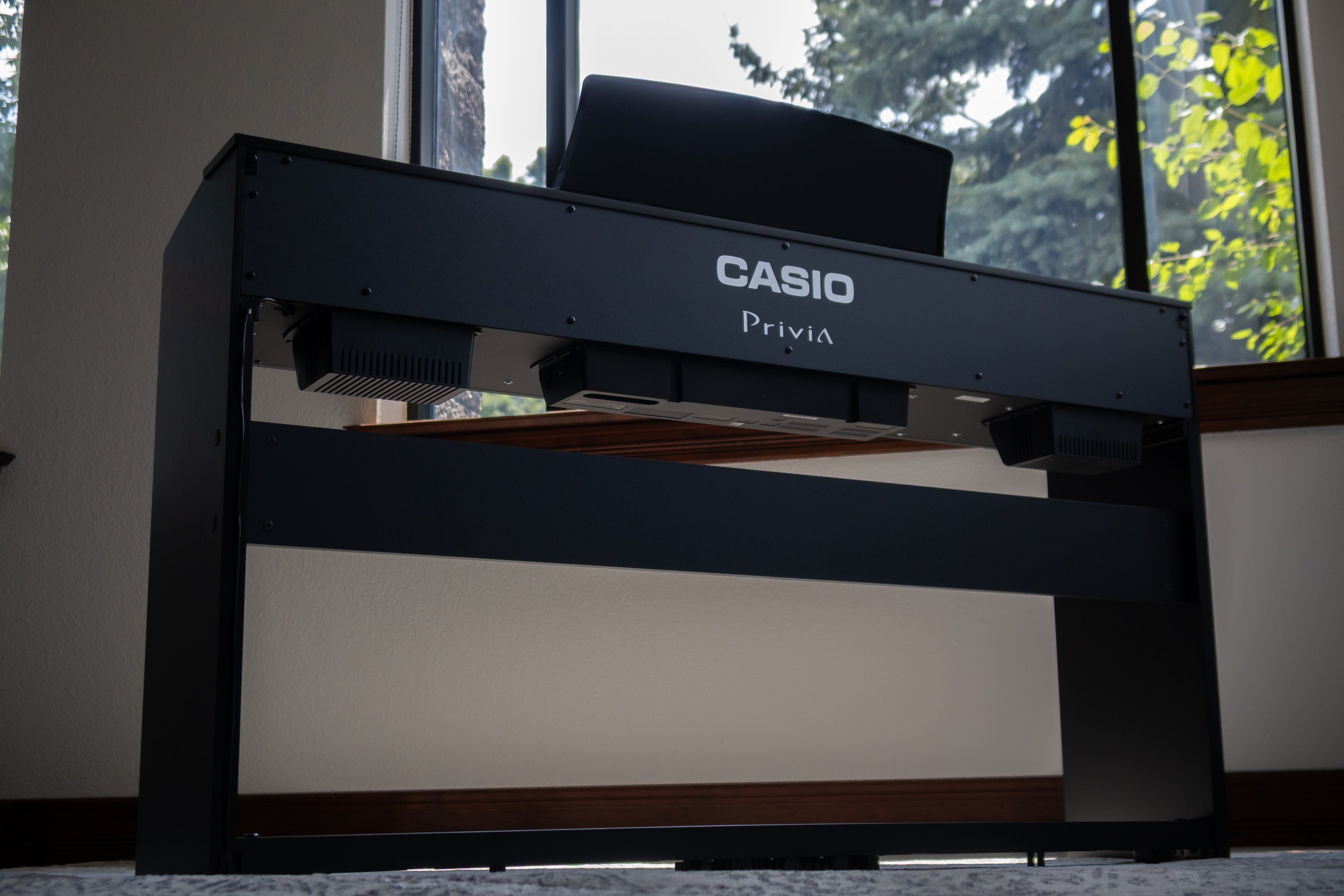 Casio Privia PX-765 Digital Piano - Black in a room with a window in the background
