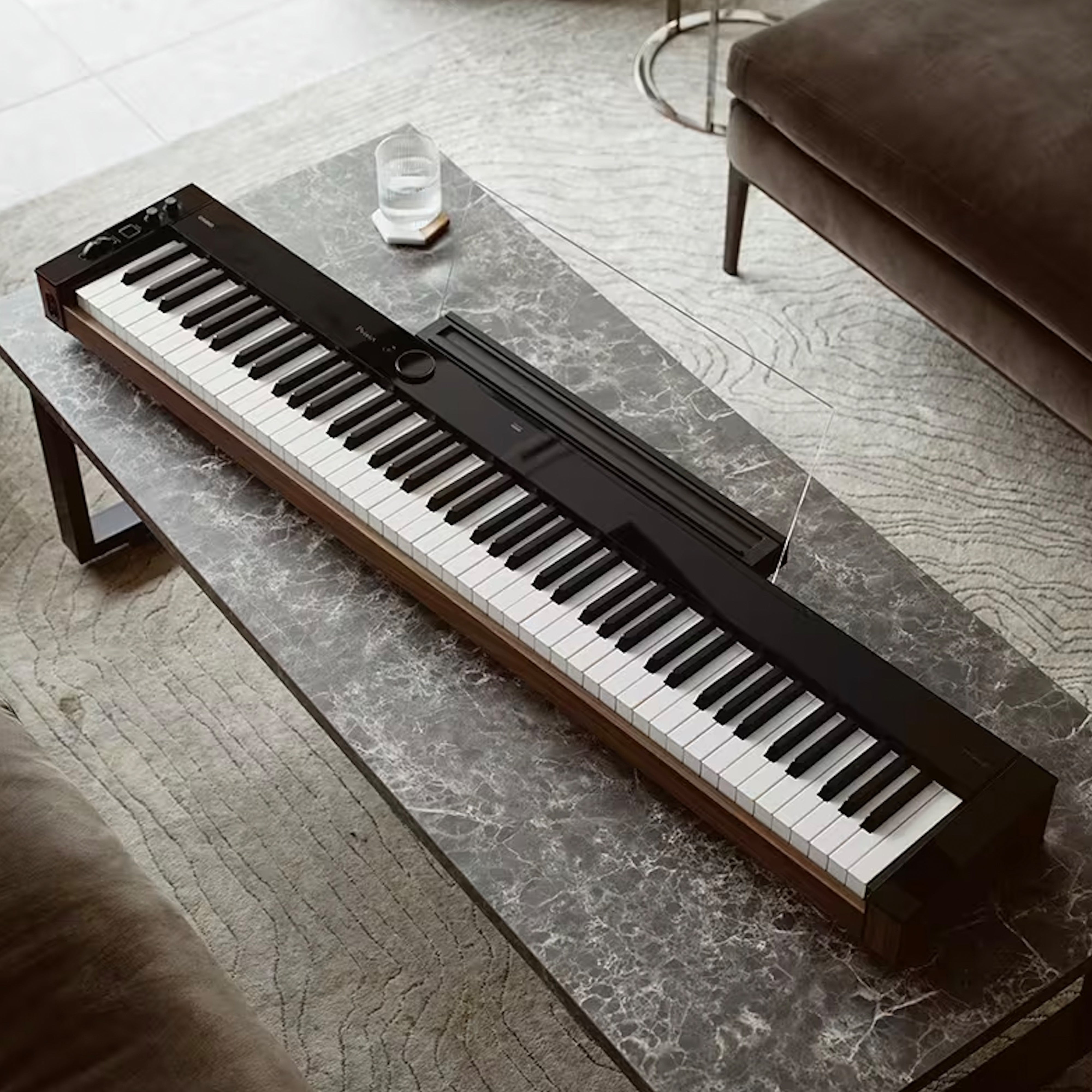 Casio PX-S6000 Digital Piano - Black - on a coffee table in a modern living room