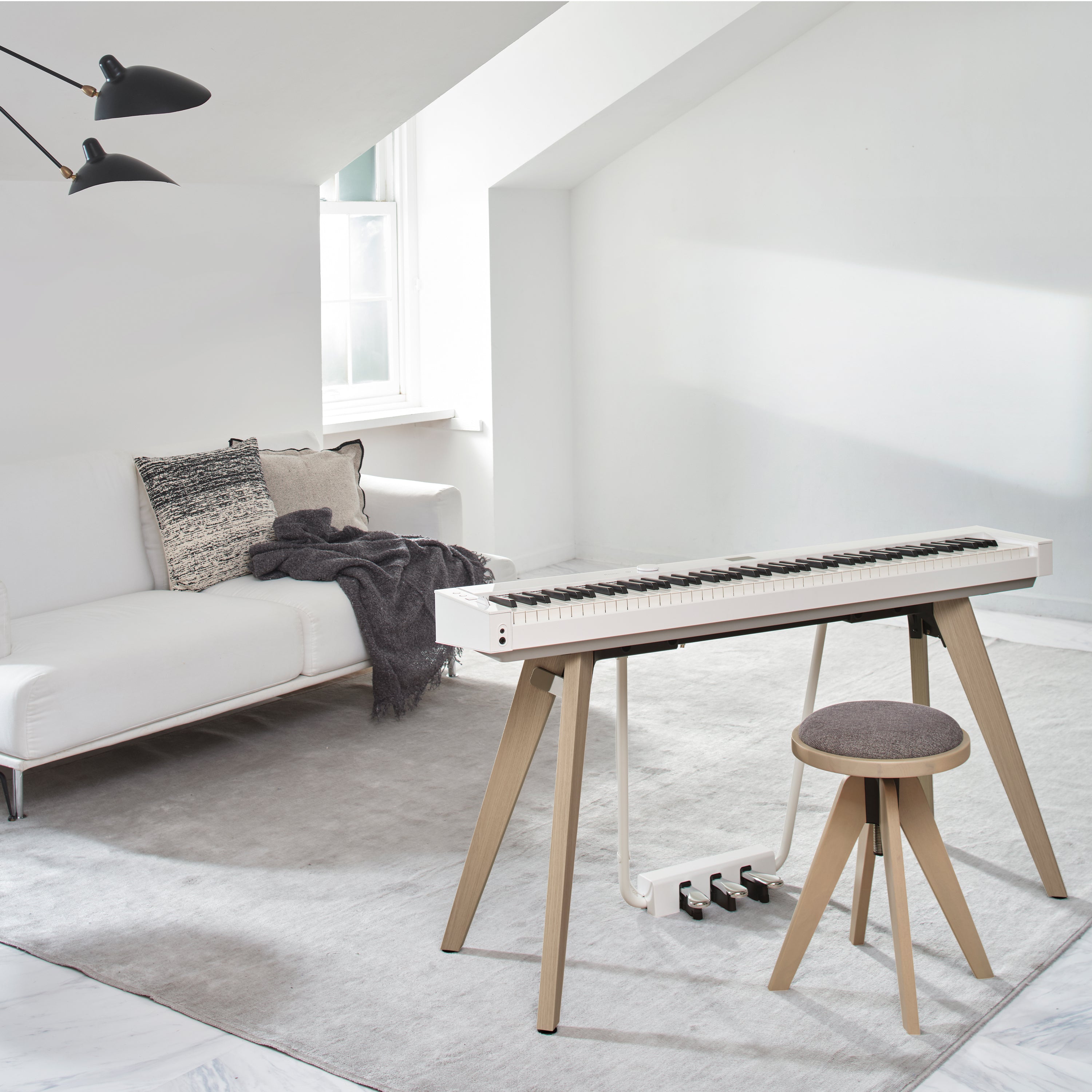 A white Casio PX-S7000 digital piano in a stylish living room