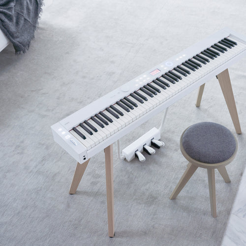 A white Casio PX-S7000 digital piano in a stylish living room from above