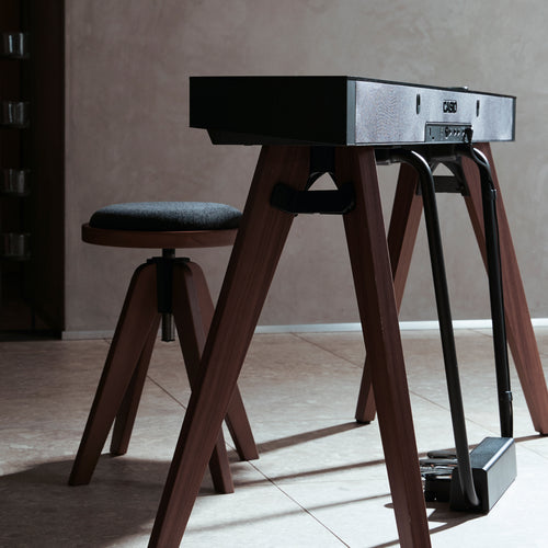 A black Casio PX-S7000 digital piano in a stylish living room from the side