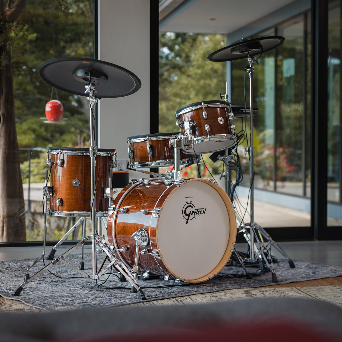 Gretsch Catalina EVO Walnut Glaze electronic drum kit by floor-to-ceiling windows, front view