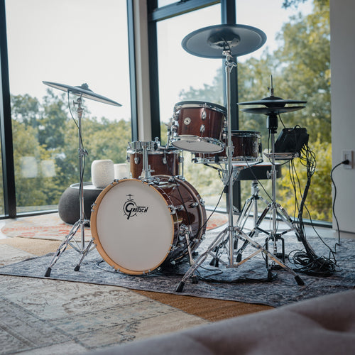 Gretsch Catalina EVO Walnut Glaze electronic drum kit in a sunlit corner with window views