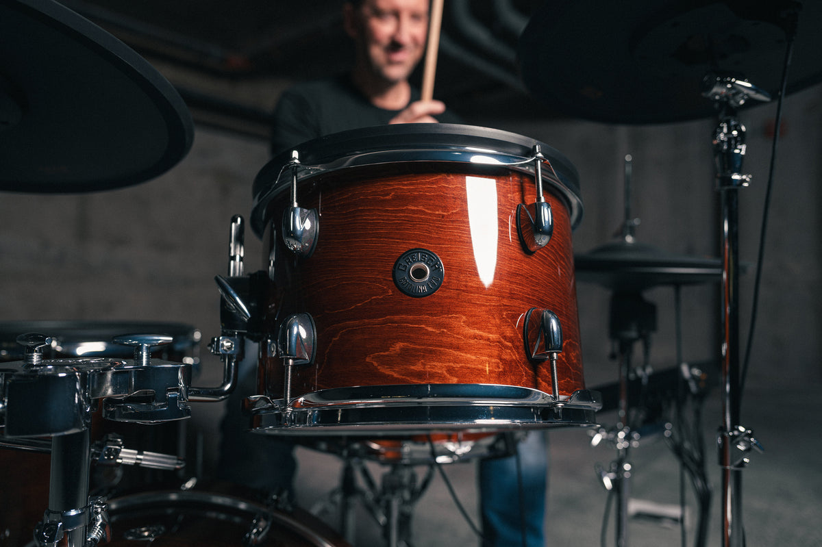 Drummer playing a Gretsch Catalina EVO Walnut Glaze electronic drum kit, rack tom in foreground