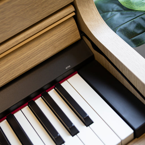 Close-up of a Roland HP704 Digital Piano - Light Oak 
