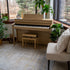 Roland HP704 Digital Piano - Light Oak in a room with plants and a window