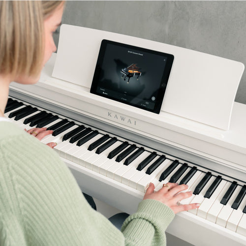 Kawai CN201 Digital Piano - Satin White - Woman playing piano using learning app