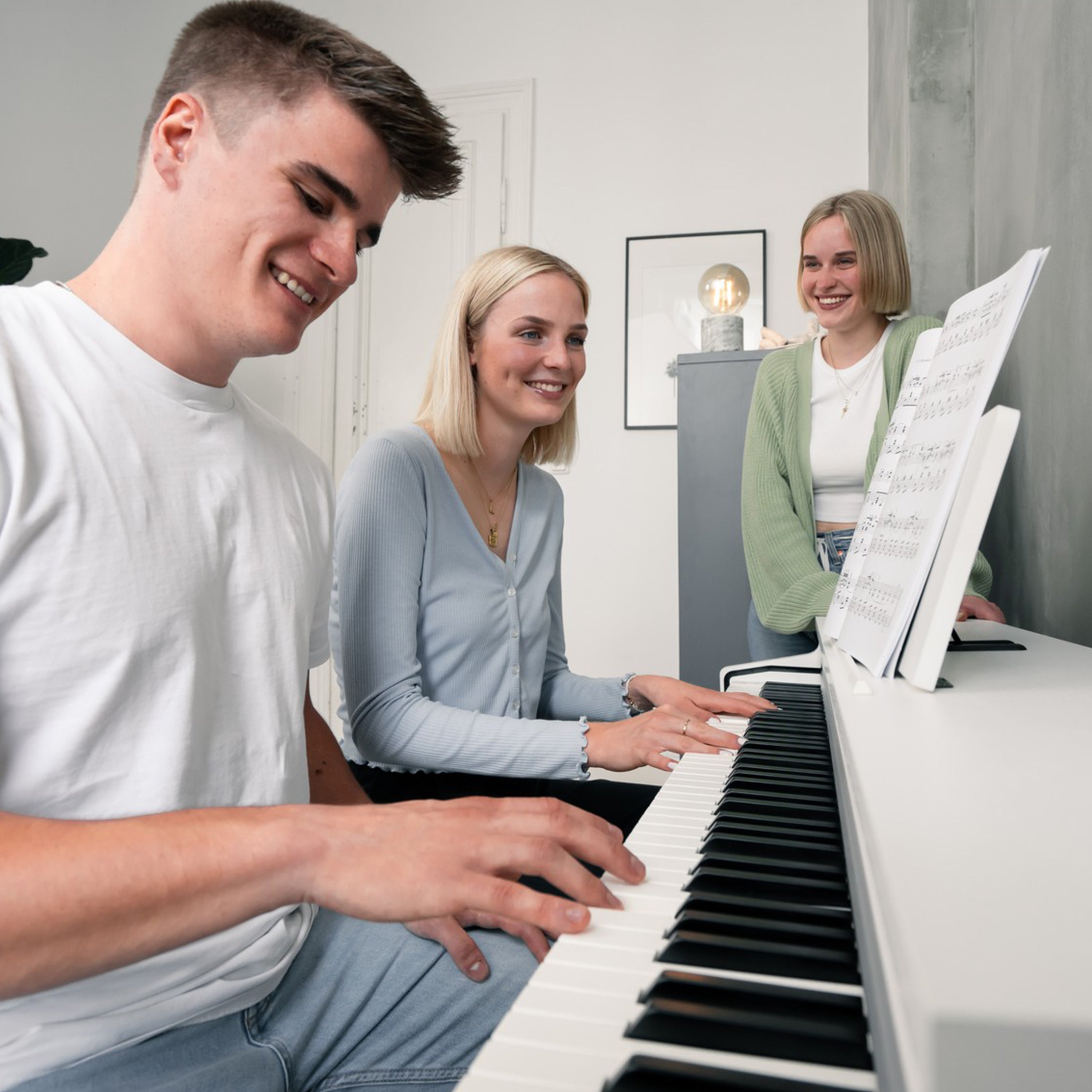A young couple playing a Kawai CN201 Digital Piano - Satin White