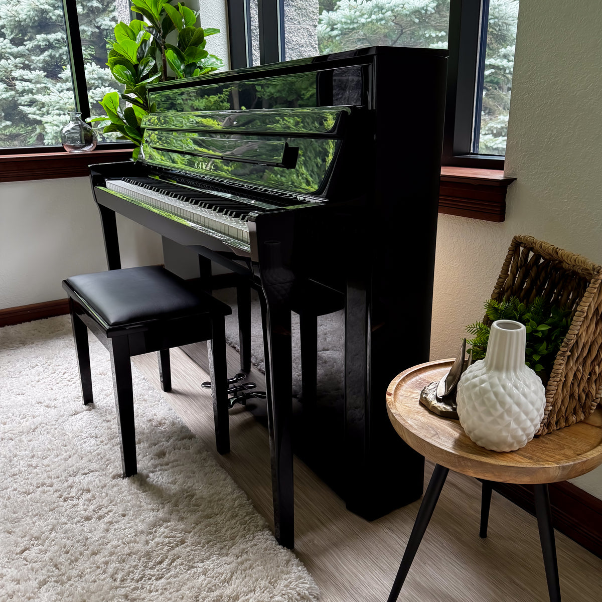 Kawai NOVUS NV6 Hybrid Upright Piano in a home setting, positioned next to a small wooden side table with a white textured vase.