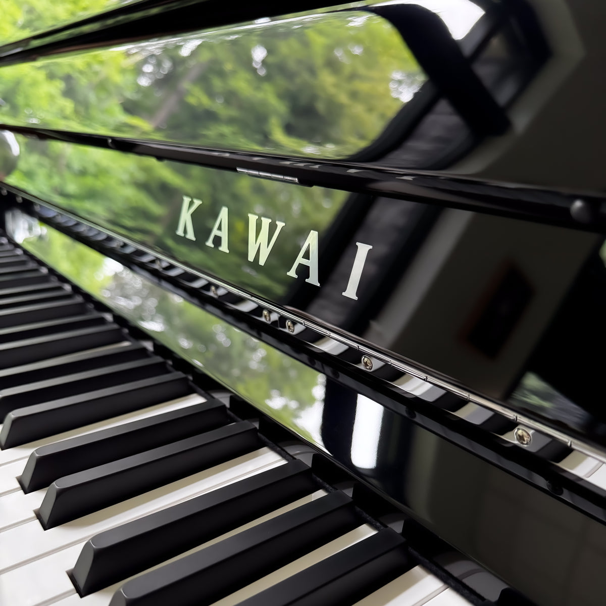 Close-up of a Kawai NOVUS NV6 Hybrid Upright Piano showing the brand name on the fallboard and black-and-white piano keys.