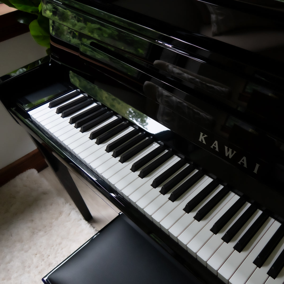 A Kawai NOVUS NV6 Hybrid Upright Piano shown at an angle, with the keyboard open and a matching black bench in front. The Kawai brand name is visible on the front.