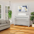 Kawai CA701 Digital Piano in Satin White in a bright, modern living room setting with a gray sofa, wooden floors, and a potted plant.