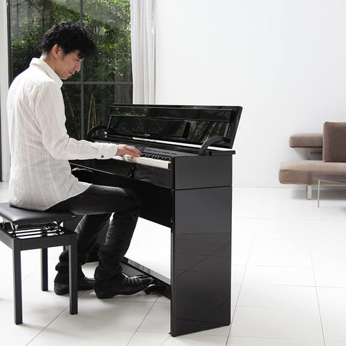 A young man playing a Roland DP603 Digital Piano in a stylish room