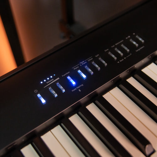 Close-up of a Roland FP-30X Digital Piano - Black with illuminated control panel