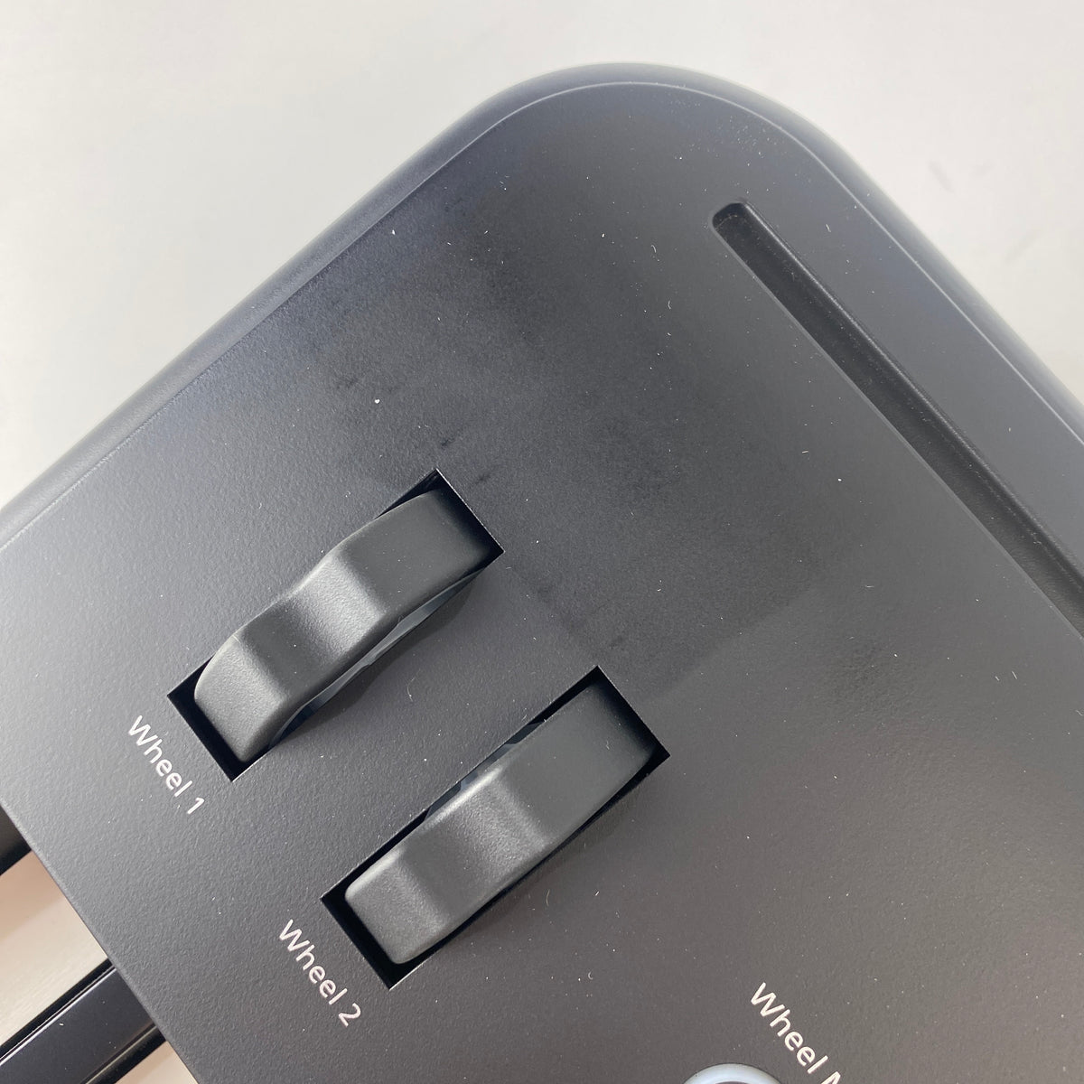 Close-up of Roland FP-E50 pitch and mod wheels on left end panel with light scuffs