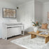 Roland HP702 Digital Piano - Satin White in a modern living room with a coffee table and decorative items.