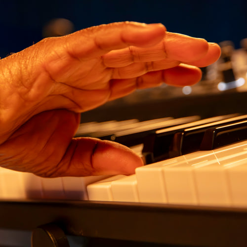 Close-up of a hand on a Roland V-Stage 76 Stage Piano, showing the waterfall keys