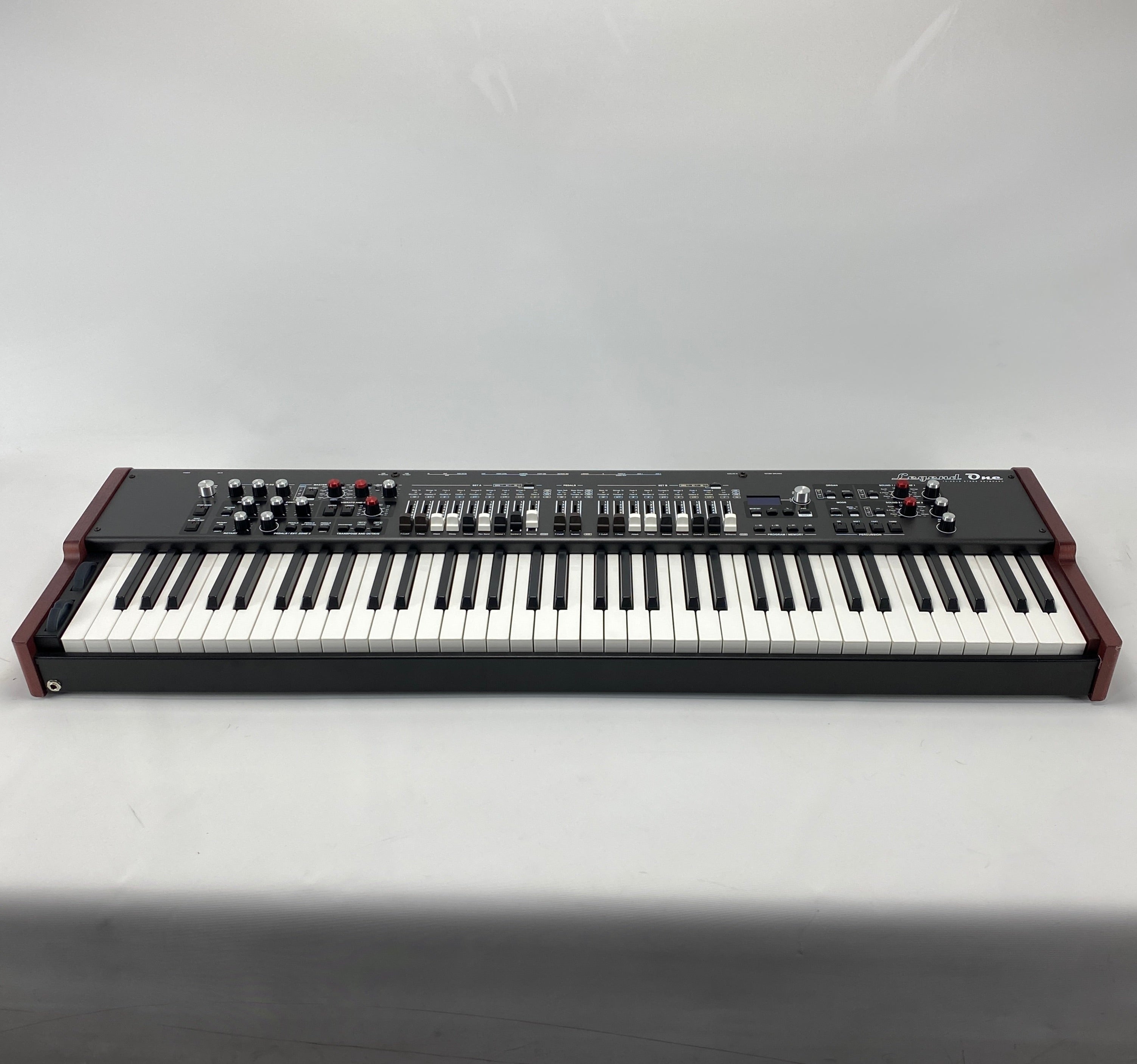 Viscount Legend One 73 stage keyboard shown from the front on a white background, with its control panel of knobs, sliders, and drawbars above a 73-note waterfall keybed and reddish-brown wooden side panels.